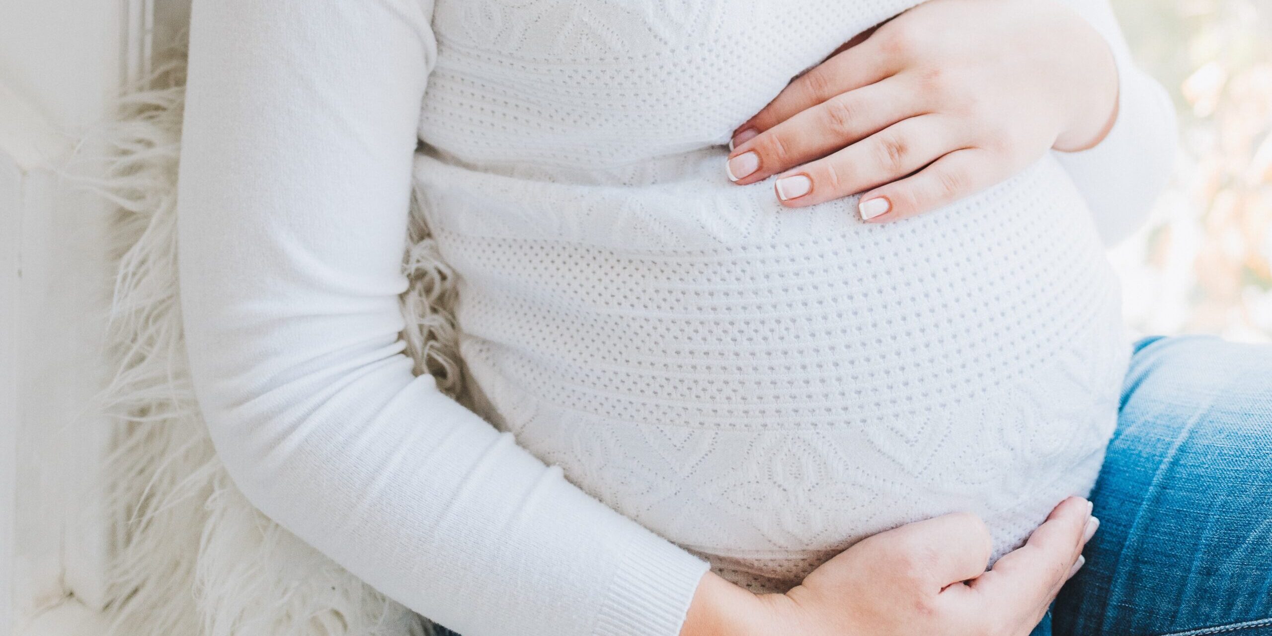 Pregnant caucasian woman with hands on her belly